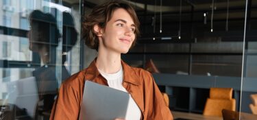 portrait young female manager office worker with laptop digital nomad programmer working her1