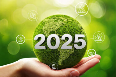 Globo verde con el número 2025 en una mano, representando el futuro de las normativas ESG."