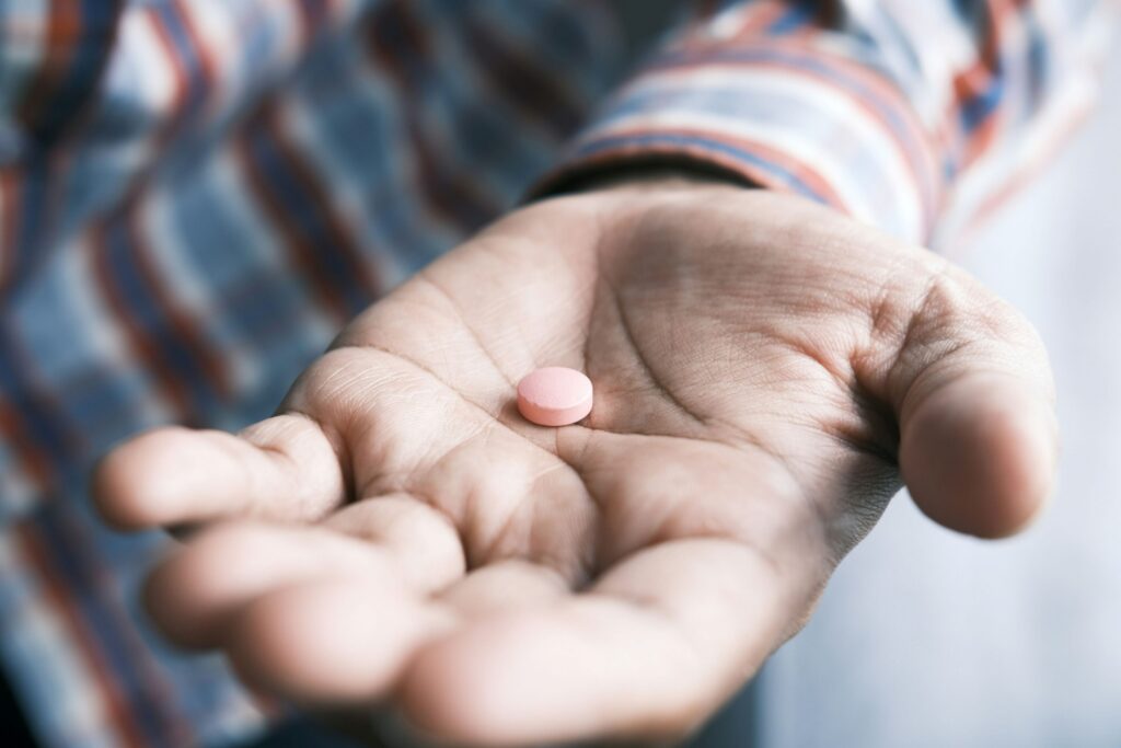 une personne tenant une pilule dans sa main