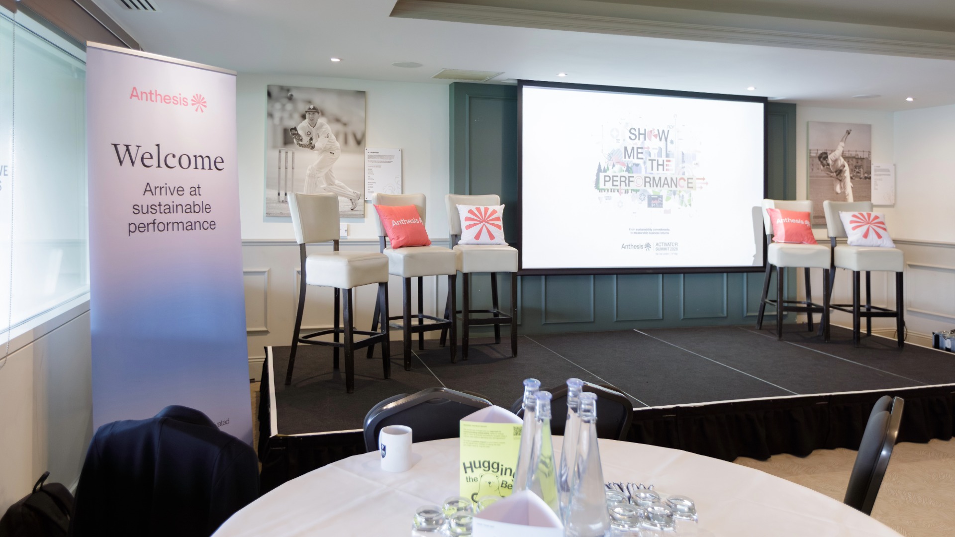 Anthesis Activator Summit: Show Me the Performance Stage with stools with Show Me the Performance as the backdrop on the screen