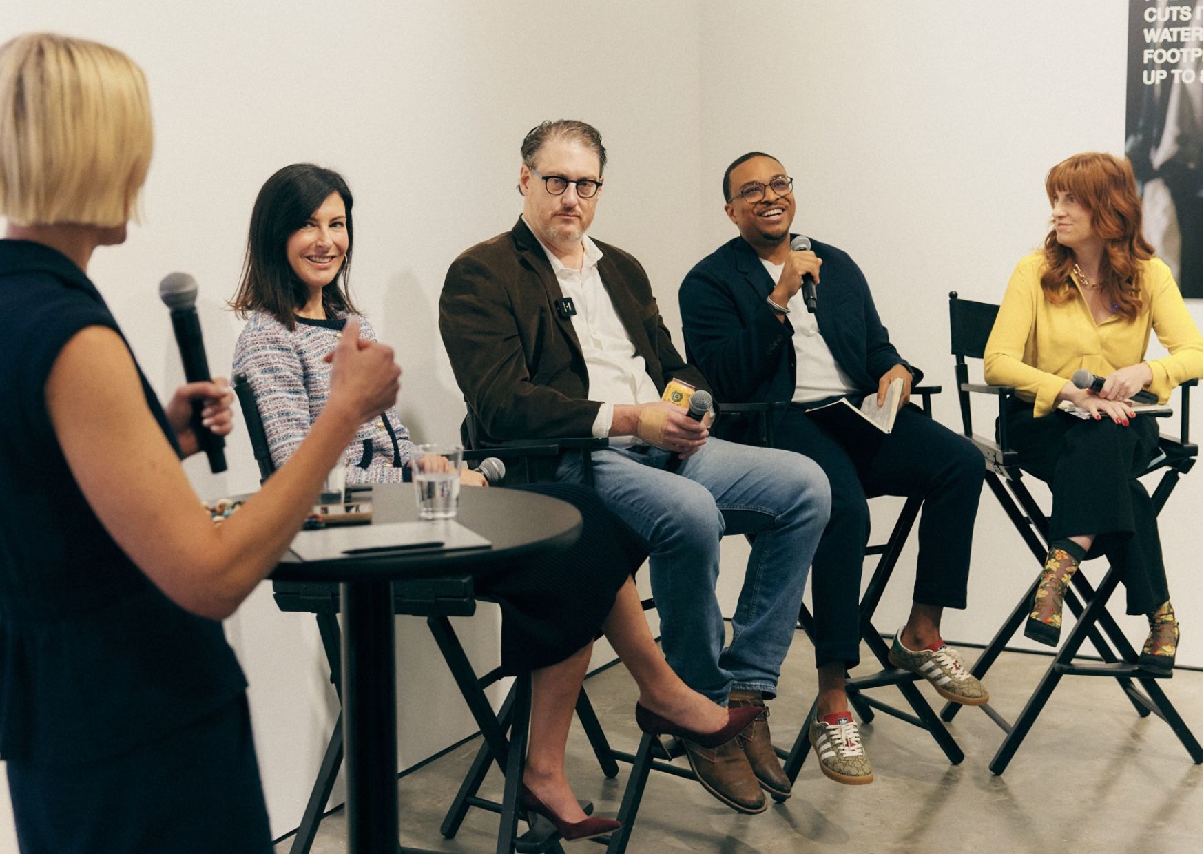 A panel of speakers sat on chairs with microphones